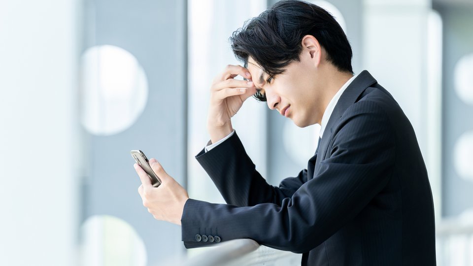 スマートフォンで購入希望者の情報を確認する営業担当者